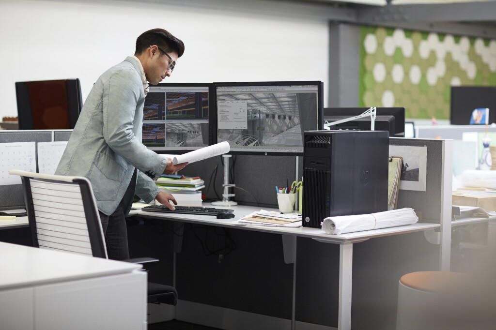 Ein Mann steht vor einer HP Z Workstation mit zwei Monitoren.