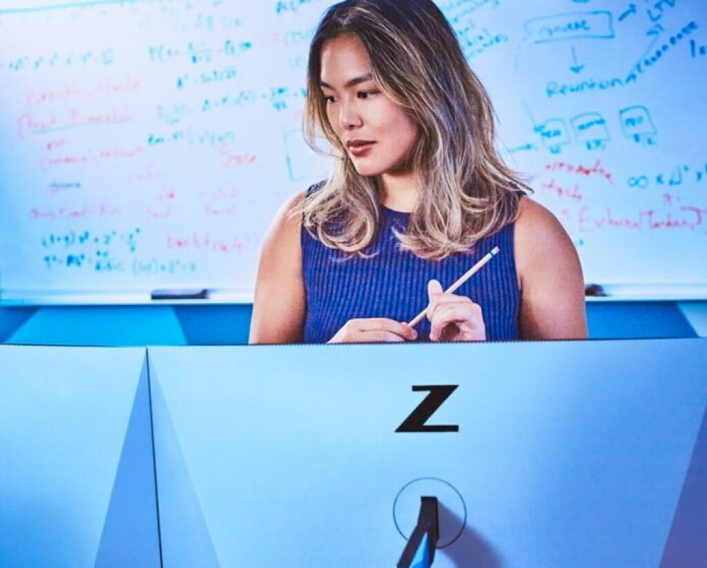 Auf dem Bild sieht  man eine Frau, welche vor zwei HP Z Monitoren steht und im Hintergrund sieht man ein Whiteboard.